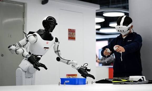 A person in a VR headset teleoperating a humanoid robot to capture training data.