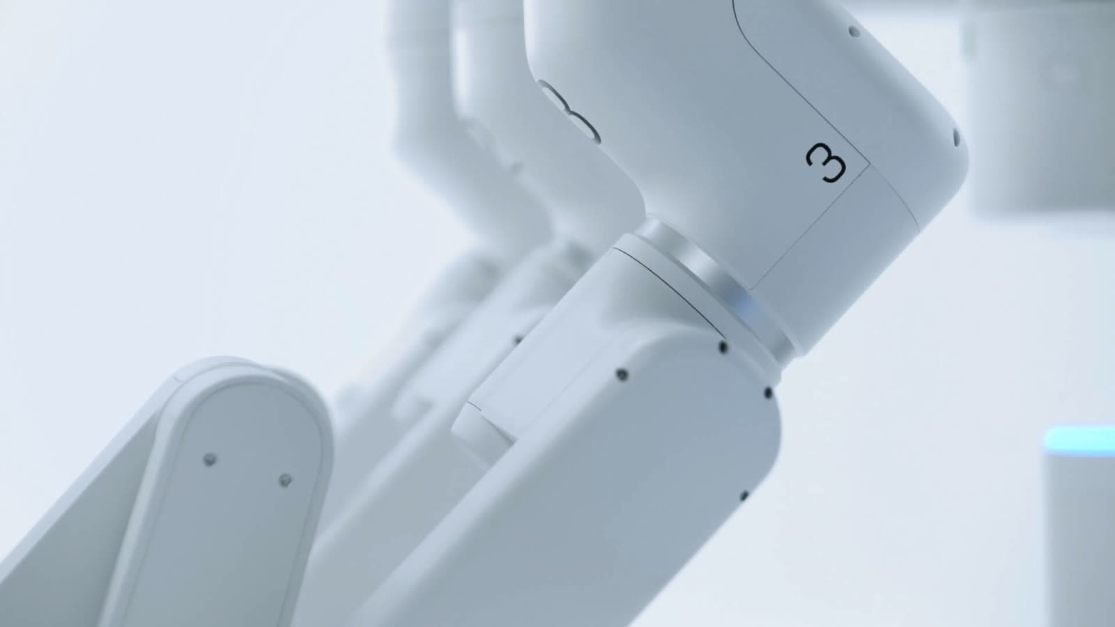A close view of the white robotic arms of Cornerstone Robotics' Sentire surgical system.