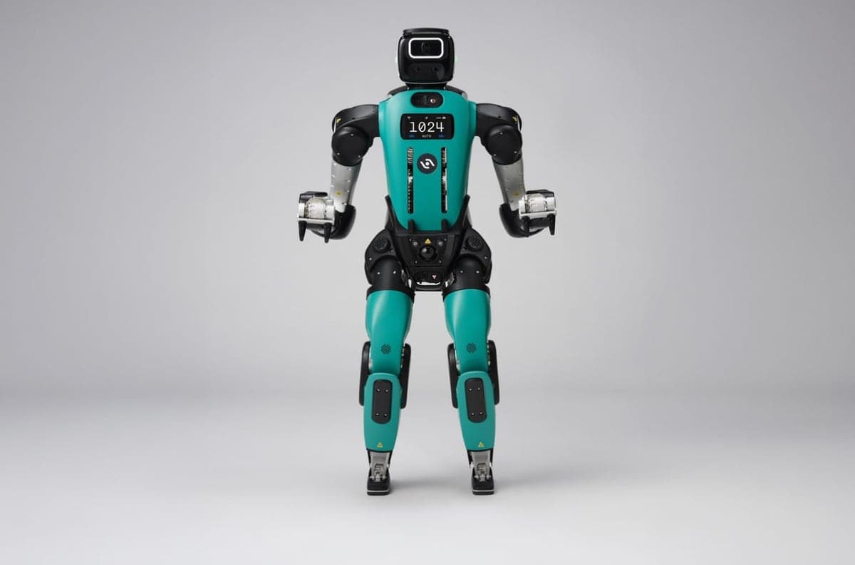 Agility Robotics' Digit 5 humanoid standing on a grey studio floor, teal and black body, a small screen on its chest reading 1024.