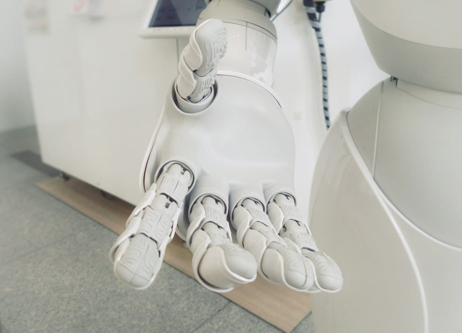 Close-up of a white robotic arm reaching toward the camera, its joints in focus.