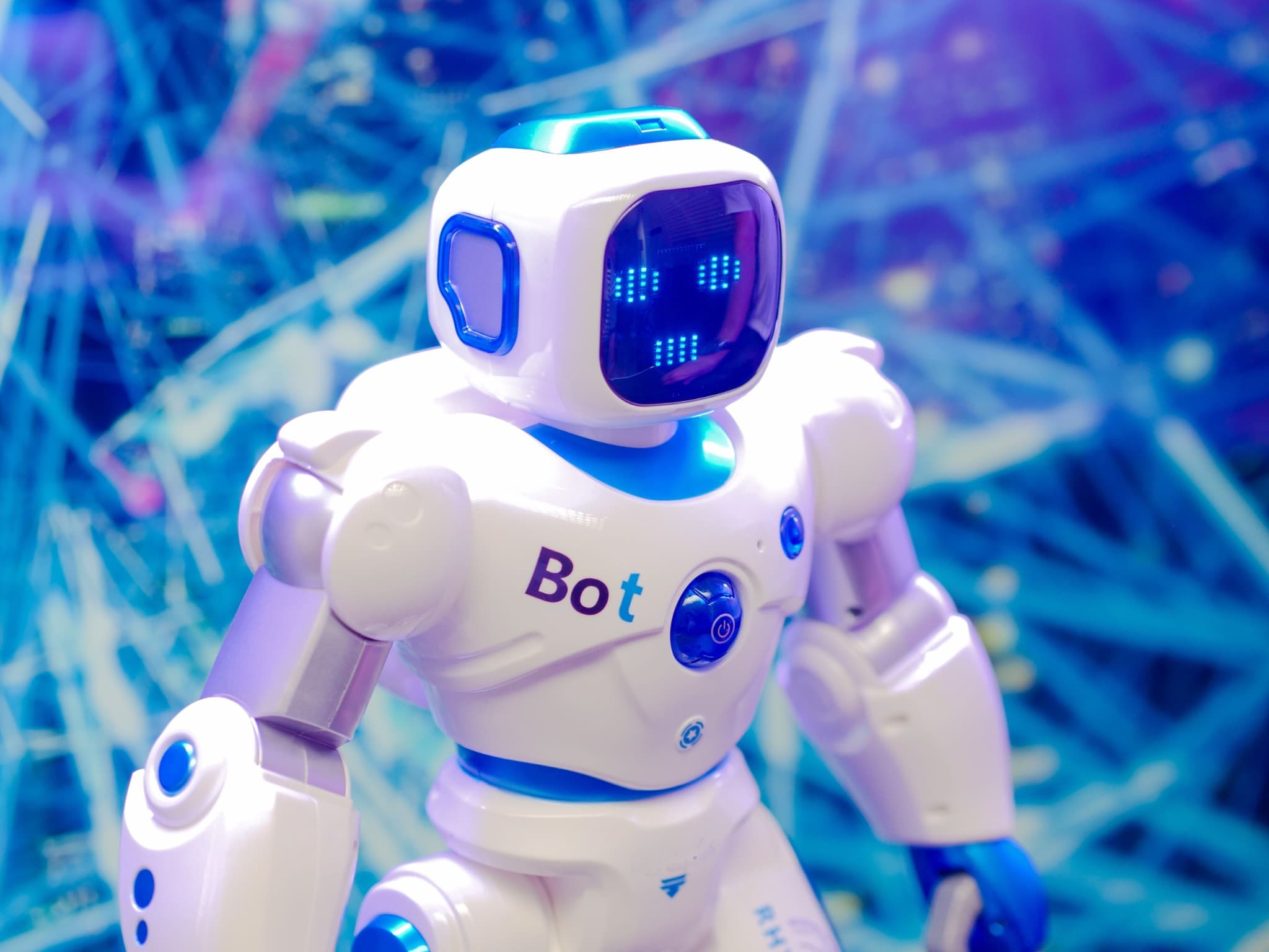 A small white and blue humanoid robot against a glowing blue network background.